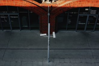 Câmeras de segurança instaladas na fachada de um edifício urbano voltado para a rua.